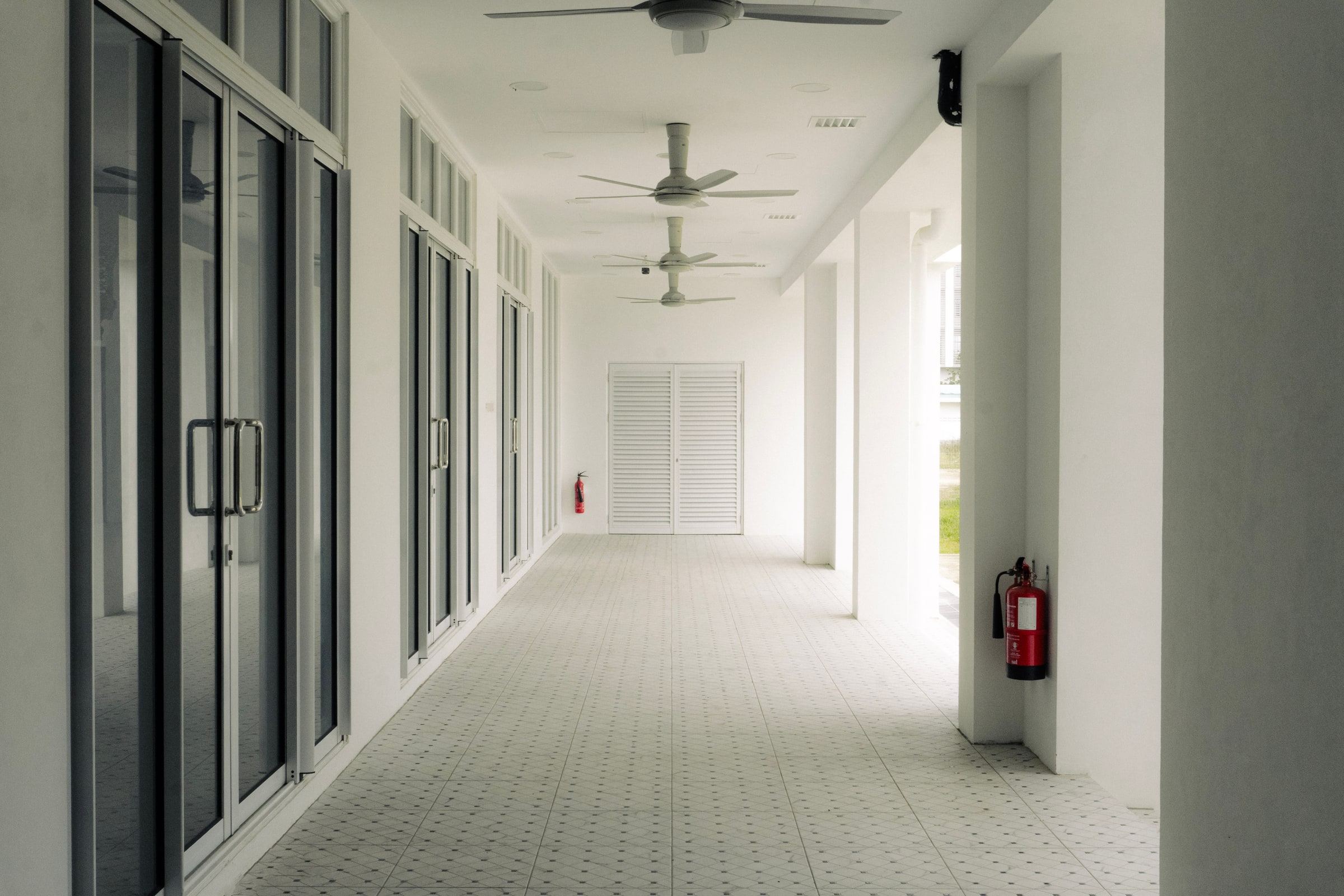 A covered verandah at Masjid Baru RPN Kg Rimba with patterned floor tiles and glazed doors to the prayer hall